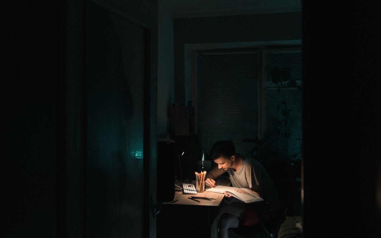 Pessoa estudando à noite em uma mesa iluminada