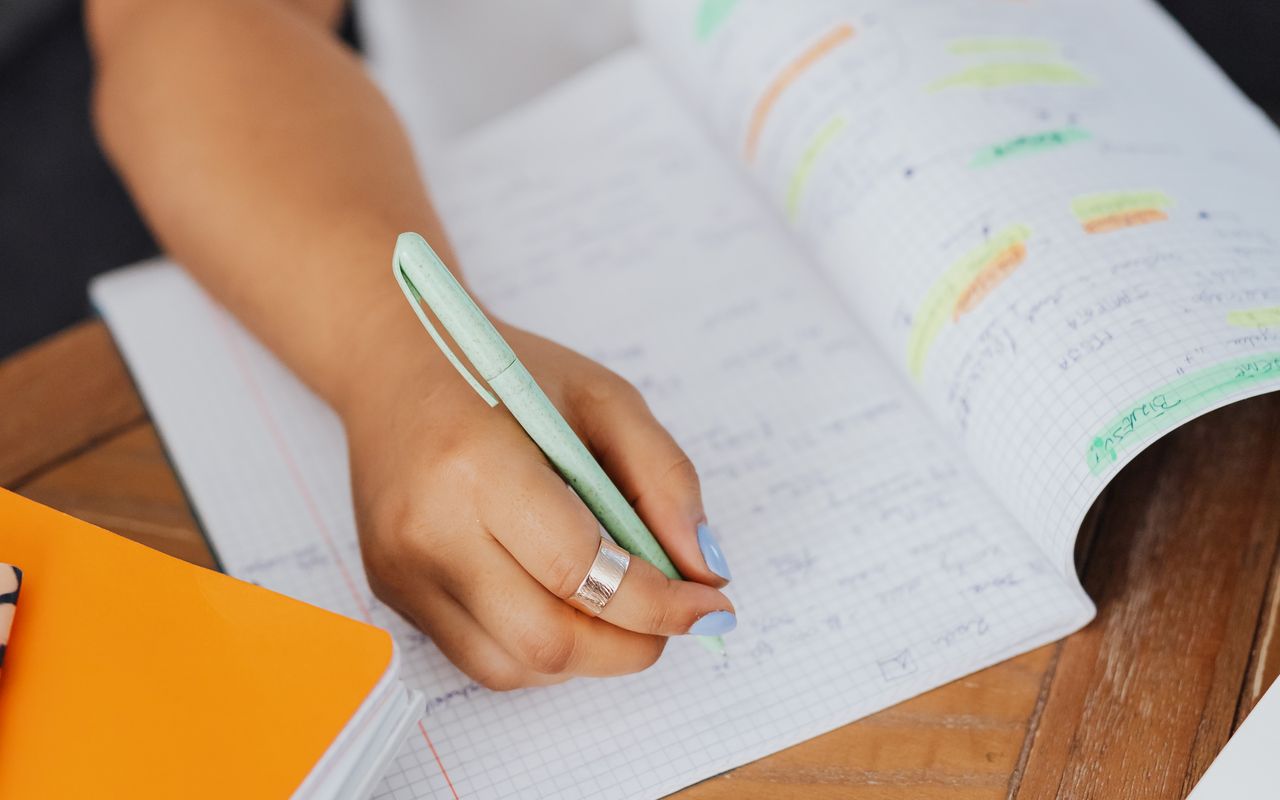 Pessoa fazendo anotações em um caderno durante os estudos