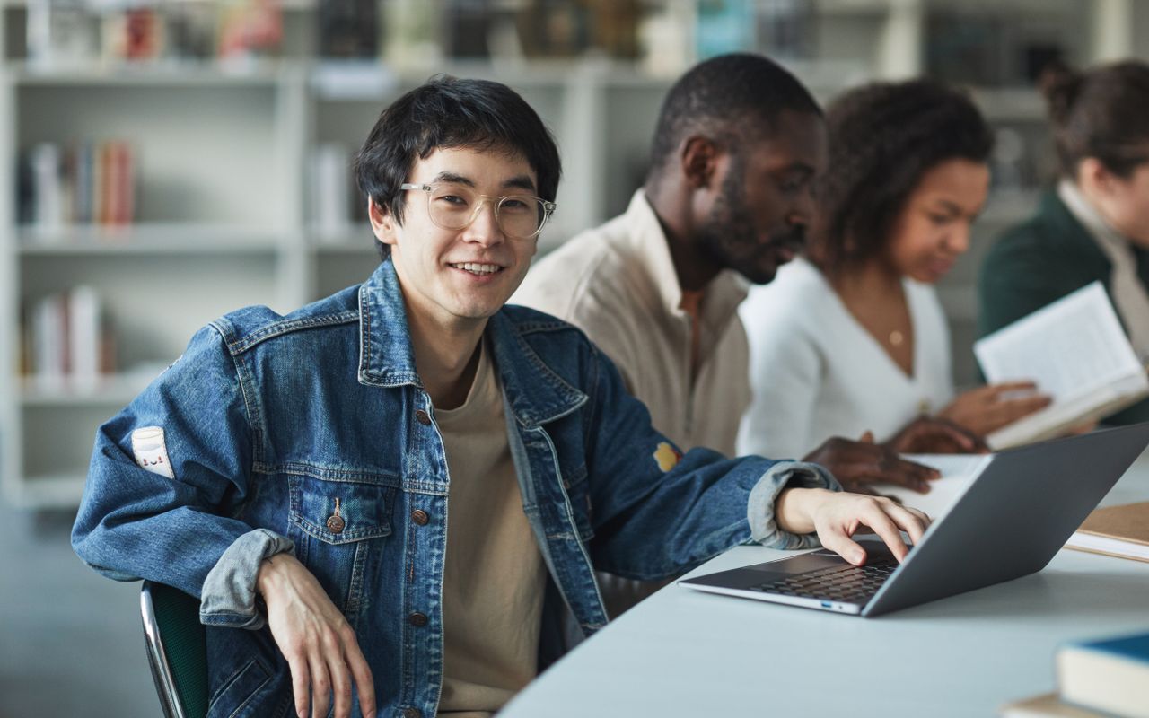 Jovens colaborando com computadores em um ambiente profissional de aprendizagem