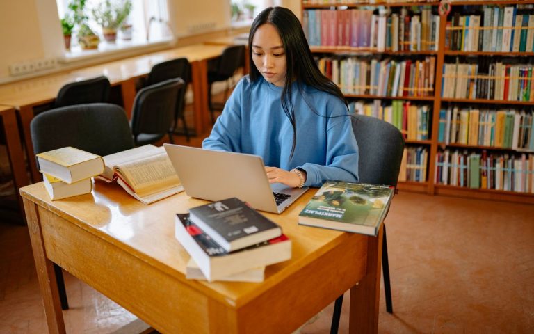 Estudante usando computador em uma biblioteca